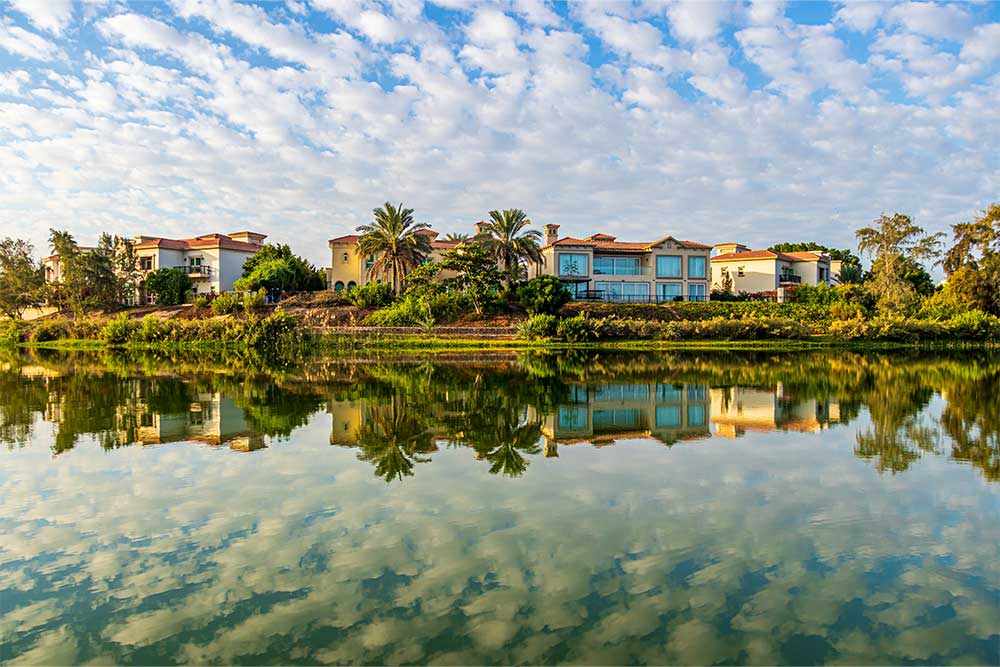 lake with reflections of buildings and trees in Duba