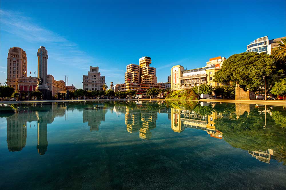 A lake with reflections of buildings and trees in Dubai, UAE