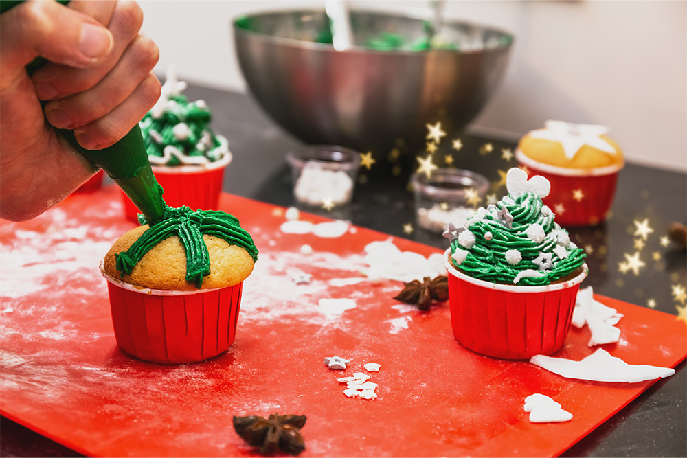 Chocolate Christmas tree cupcake with coloured sugar topping on a rustic wooden background. 