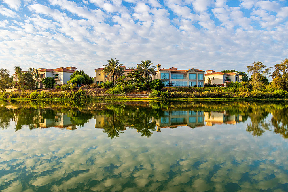 A lake with reflections of buildings and trees in abu dhabi
