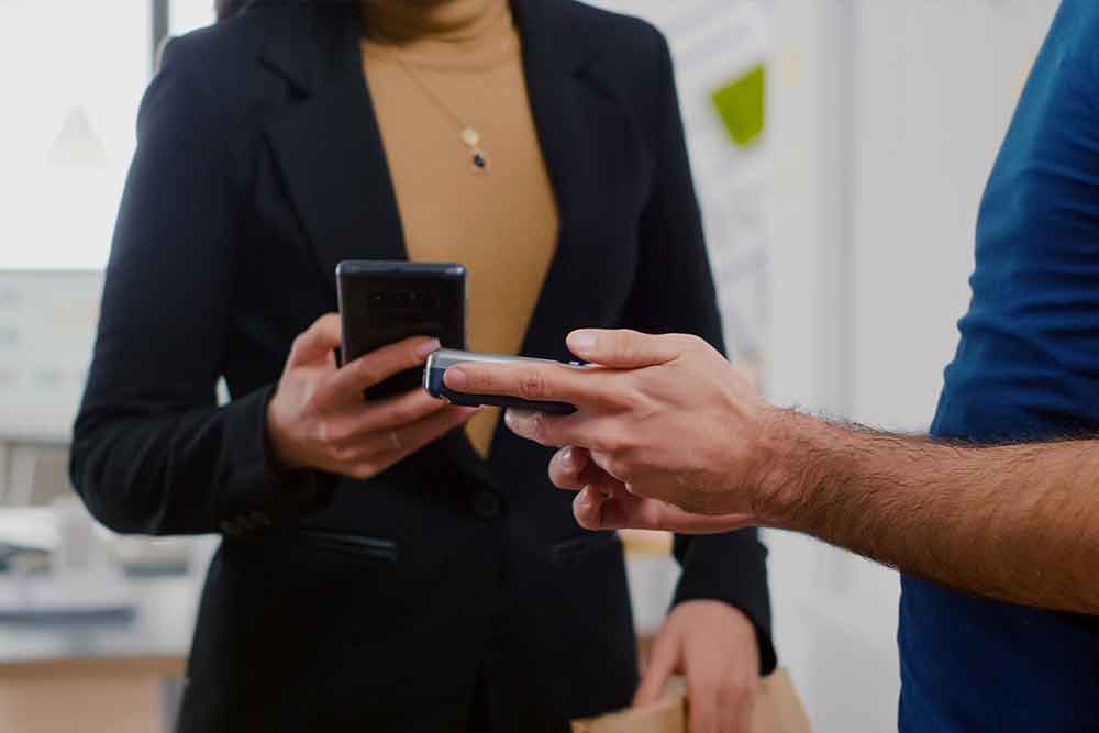 A woman on her phone showing something to a man