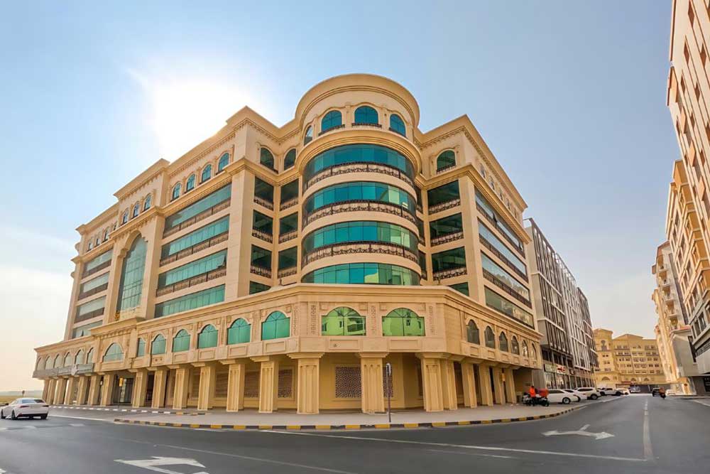 Family standing in front of a villa in one of the gated communities in Sharjah