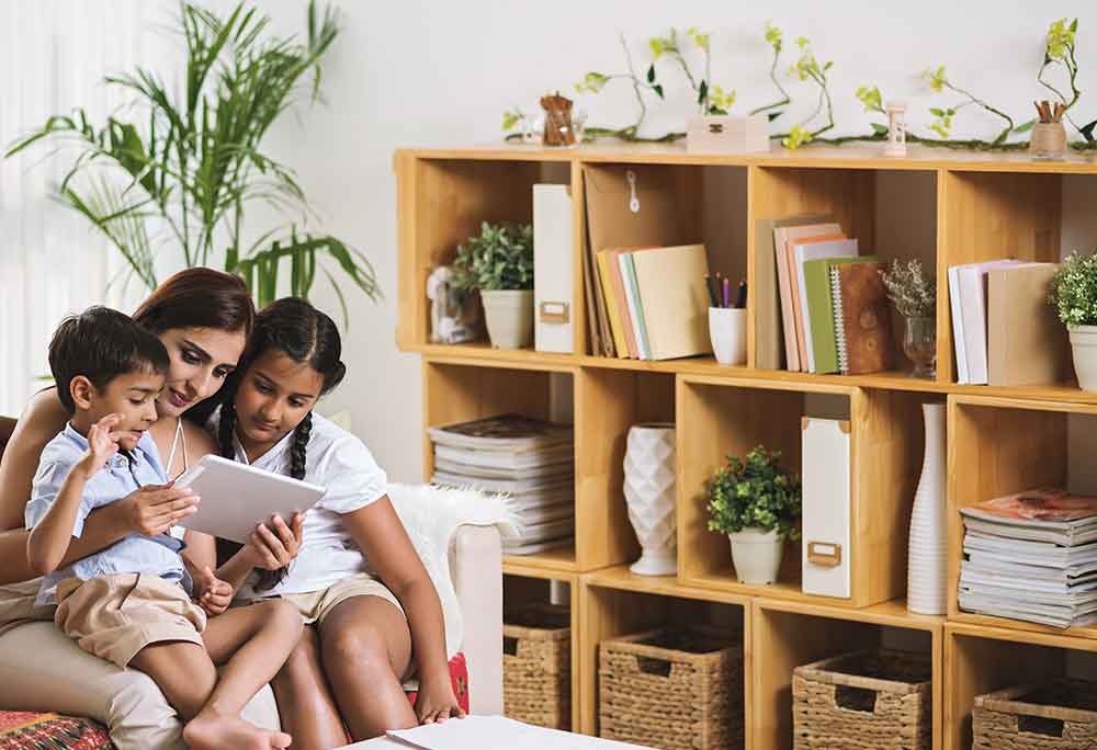 Mother reading to kids in a cosy reading corner 