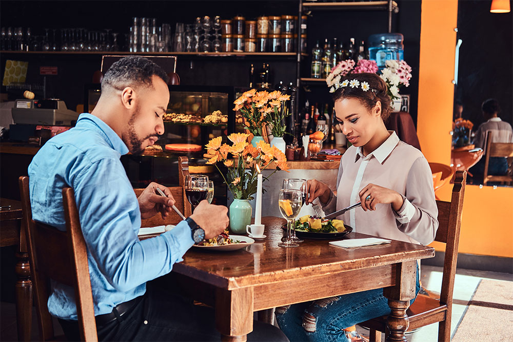 An attractive couple enjoying each other, eating in a restaurant.