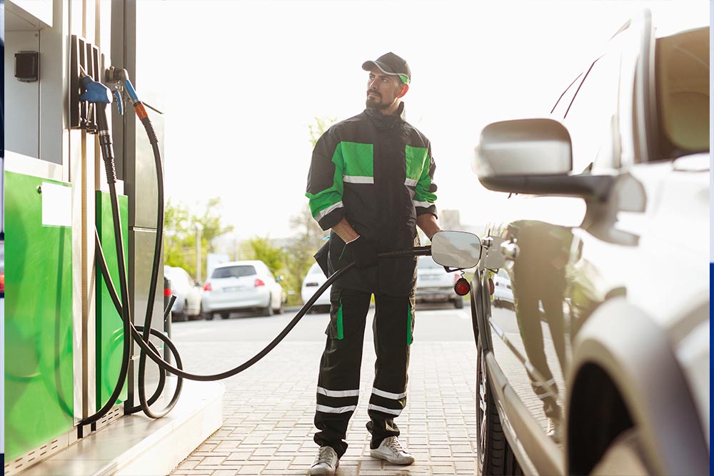 Fuel station worker filling up the car with petrol in Dubai