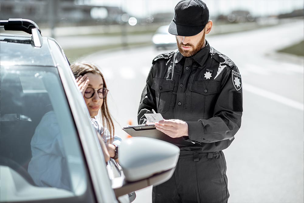 a policeman giving a fine ticket to a female driver for violating rules