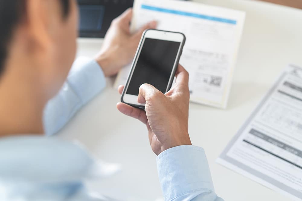 Person using a phone to pay SEWA bill