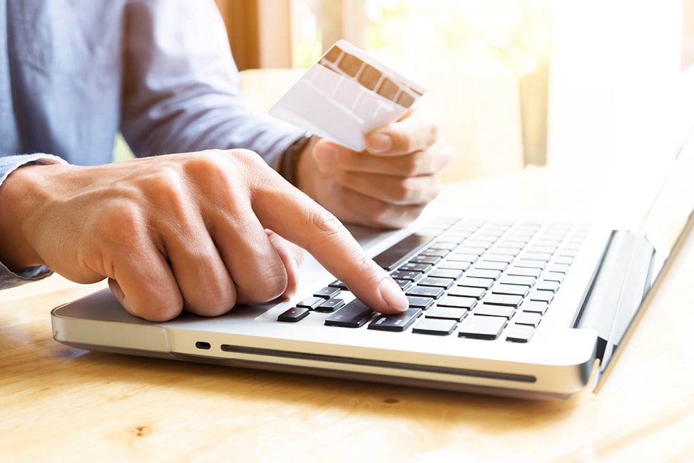 Person using a laptop to pay bill using a credit card number