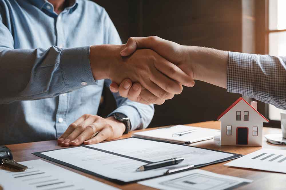 shaking hands after property ownership transfer