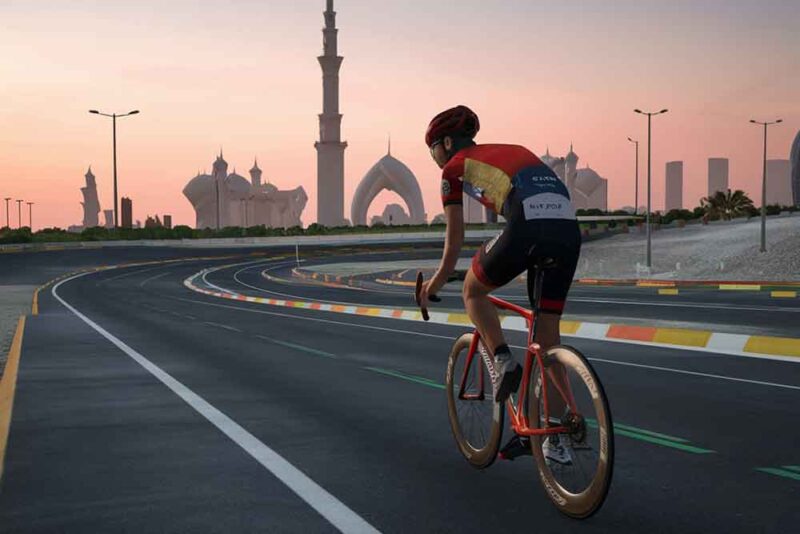  A woman cycling on track with Abu Dhabi's skyline in the background 