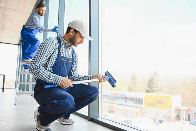 A professional staff cleaning the windows of residence