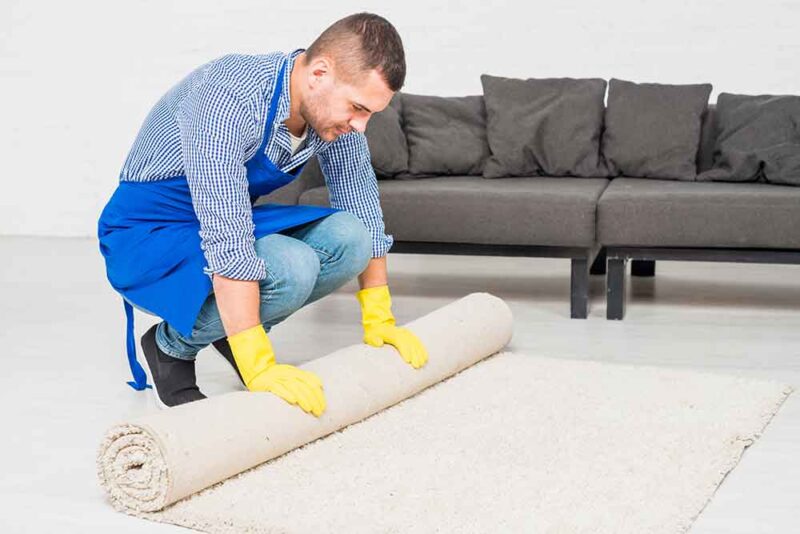 A professional carpet cleaner rolling the carpet