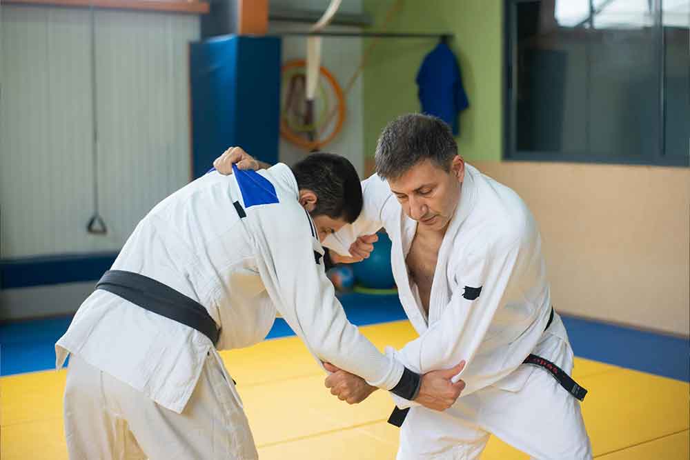 Karate instructor in Abu Dhabi demonstrating a karate action to a student