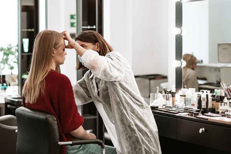 Makeup artist applying cosmetics to a client in a well-lit beauty place in Sharjah spa 