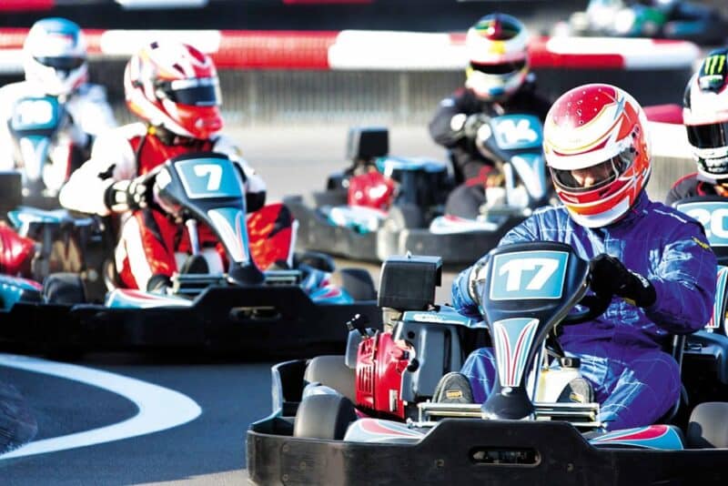 People karting with helmets on a go kart track