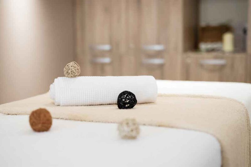 Beautifully arranged spa items with soft towels rolled in a luxurious atmosphere in Sharjah spa 