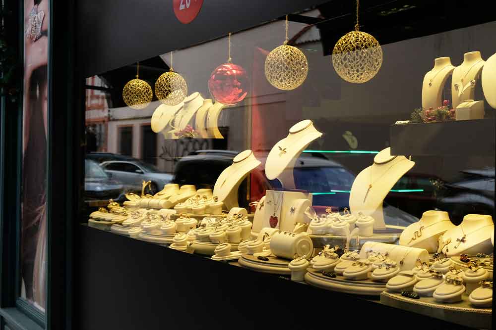 Exterior view of a bustling souvenir shop in Dubai's market, displaying jewellery.