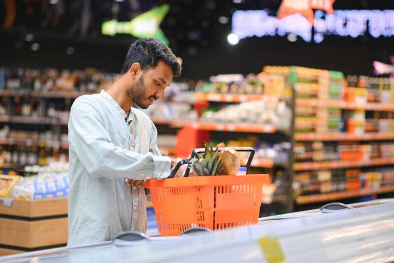 A man buying fresh fruits from Al Maya supermarket 