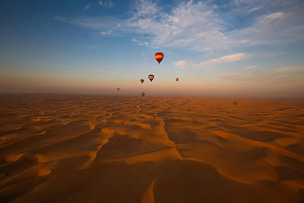 Desert image with hot air balloons in the blue sky