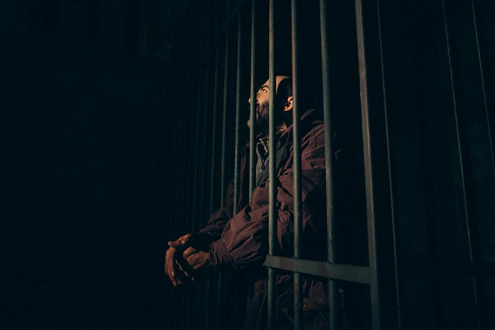 A man with a beard in jail
