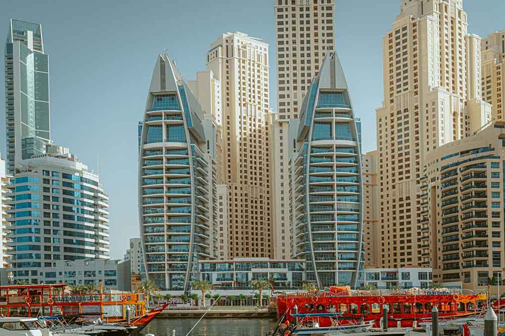 Dubai twin buildings with ferries in the sea