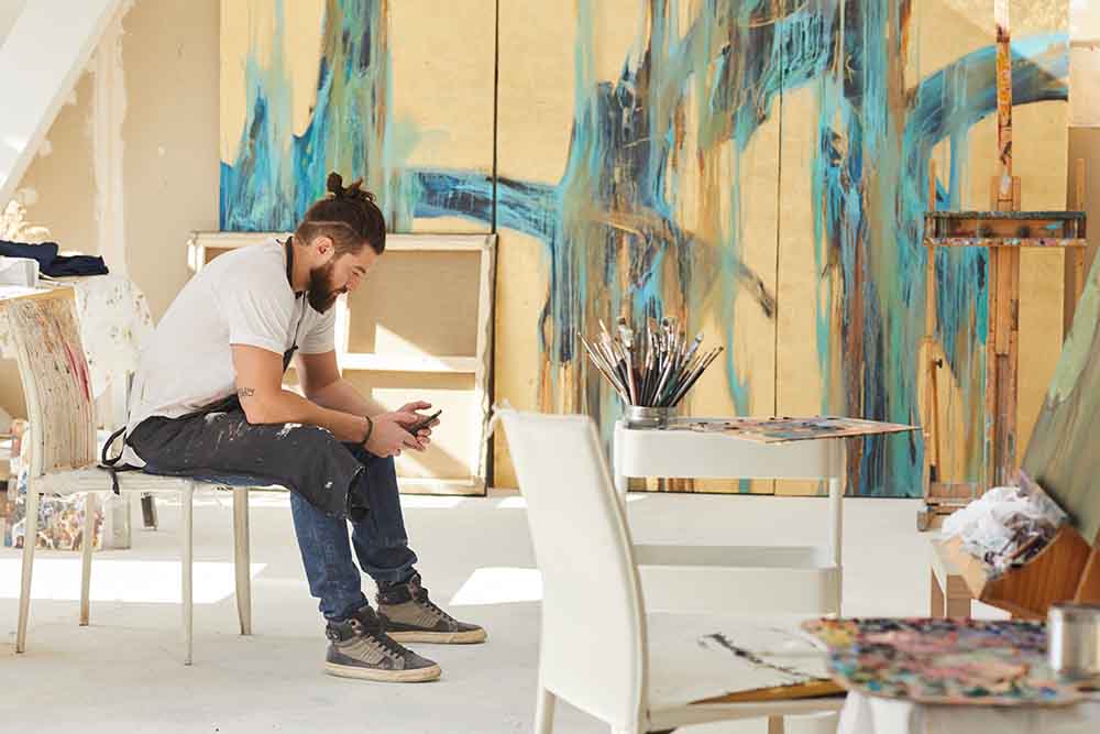 Man sitting with paintings