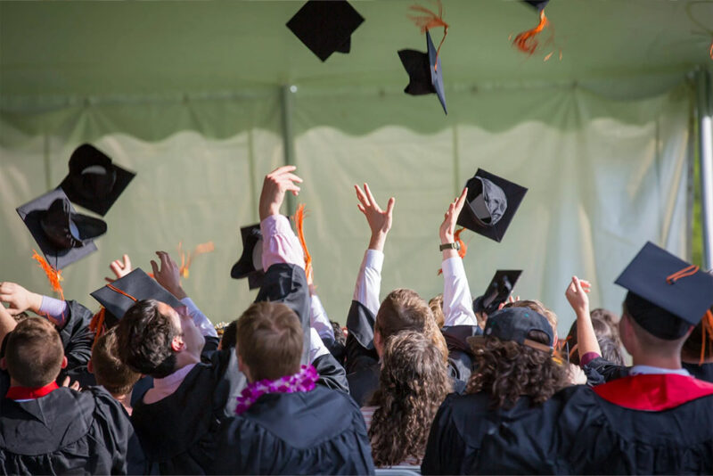 students at their convocation with black caps