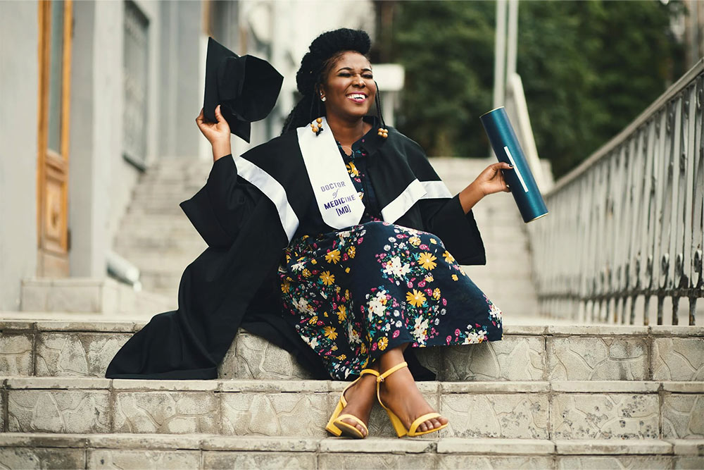 A woman on stairs smiling on her convocation day