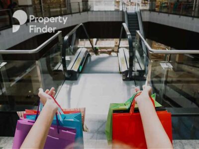 A person on the escalators with shopping bags