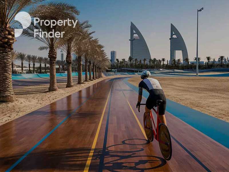 A man cycling on a track alongside a beach