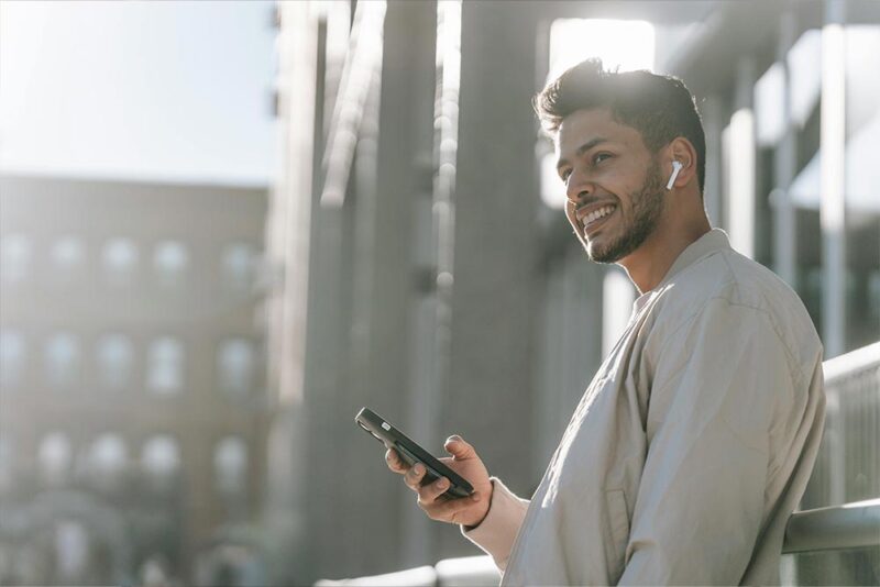 A person using his phone with earphones