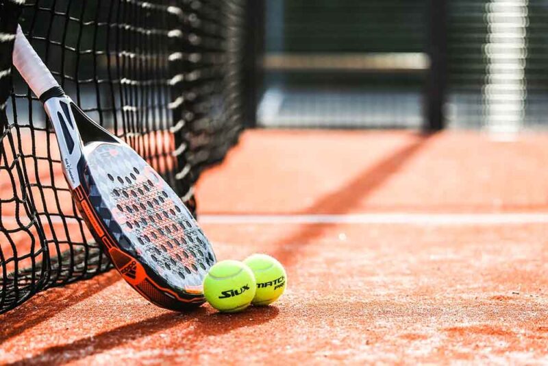 A padel racket with balls in a padel court in Dubai 