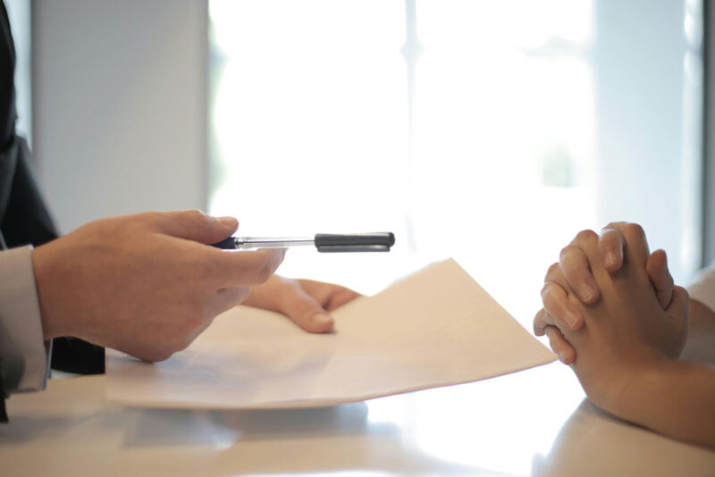 man giving contract to woman to sign 