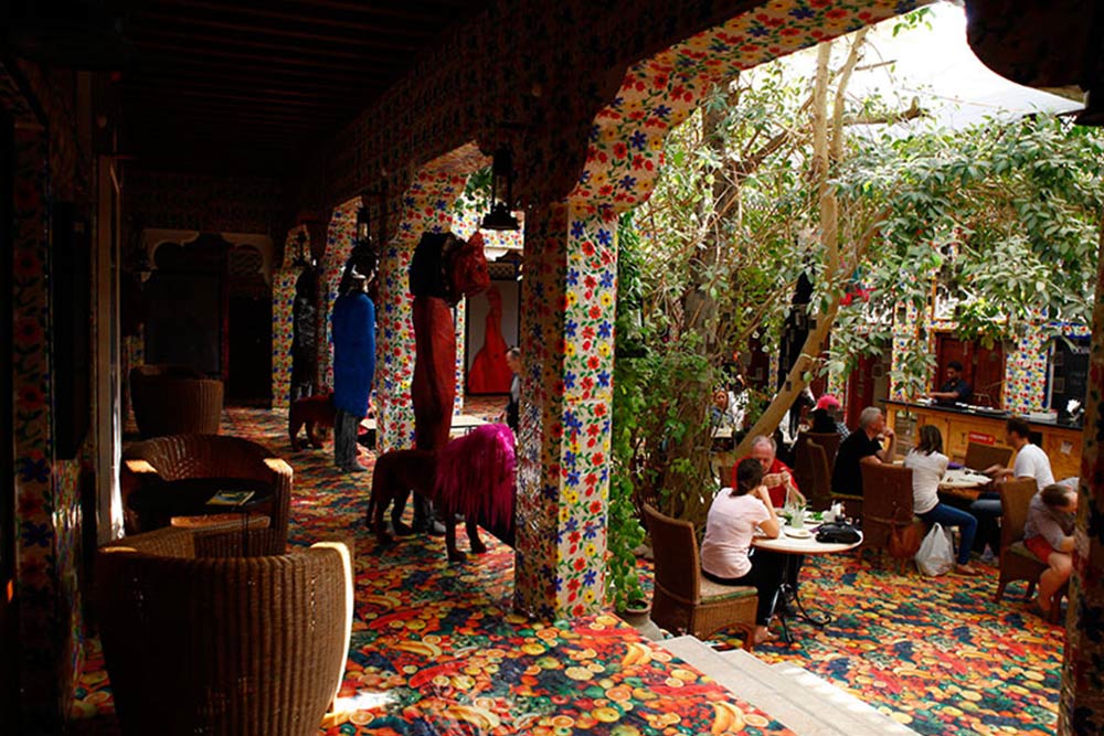 People sitting in an open cafe of a museum 