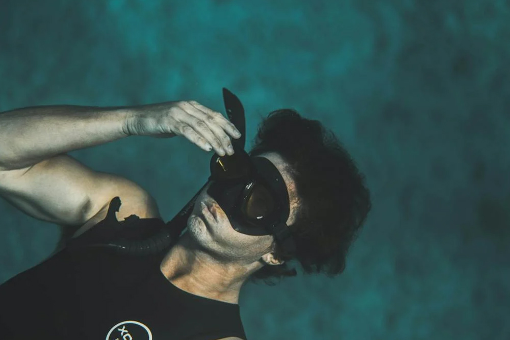 Unrecognisable male diver floating underwater of the sea