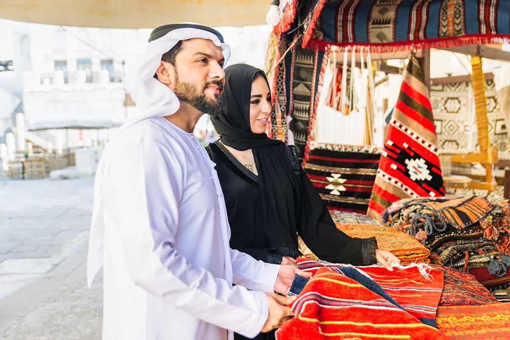 a couple shopping at a traditional souq in Souq Al Qattara