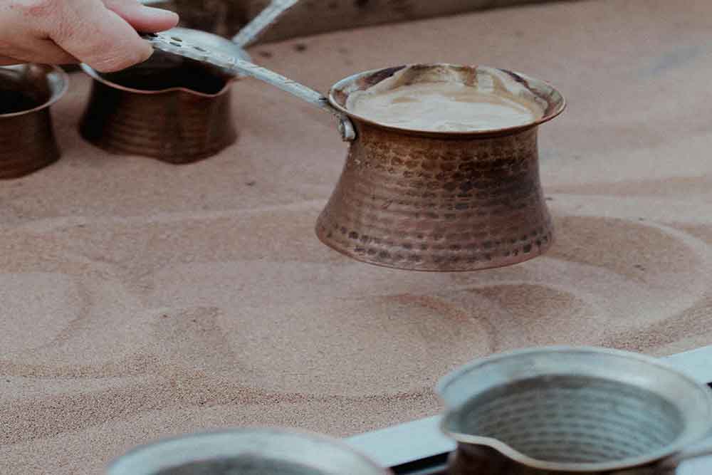 Cooking Arabic coffee in sand