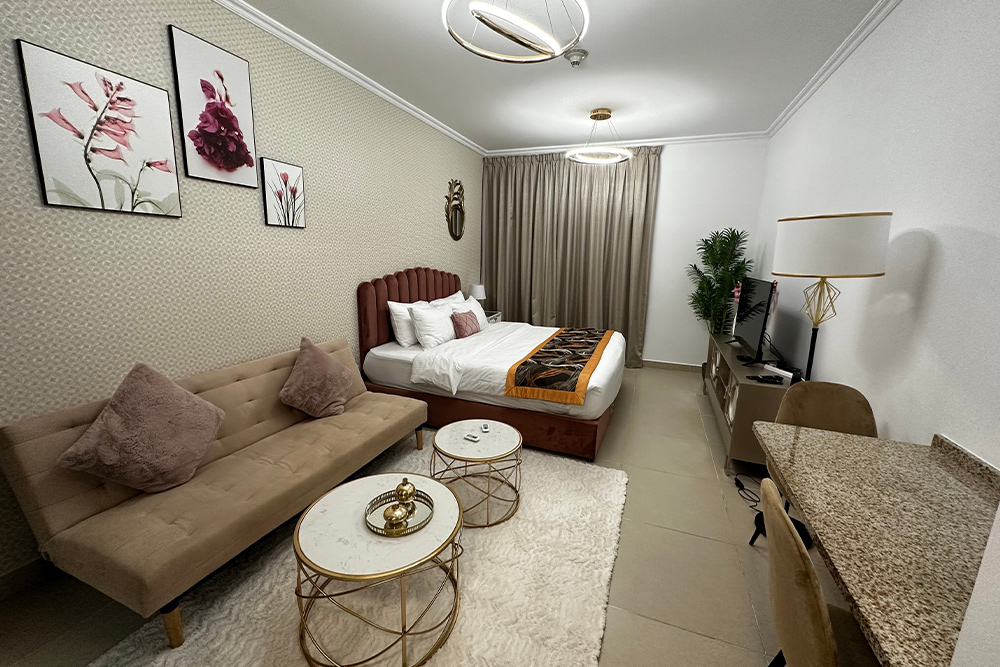 A studio apartment with bed and sofa in the room