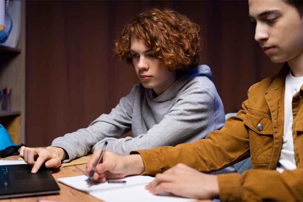 Two boys studying the admission requirements at Al Ain University