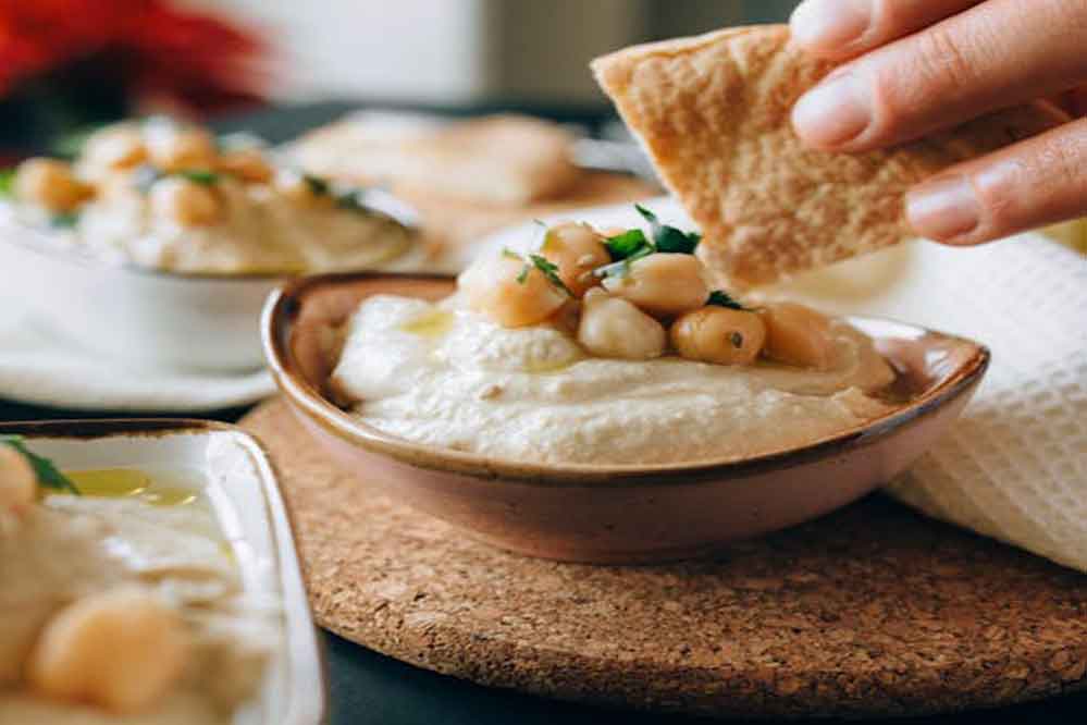 A slice of pita bread with hummus