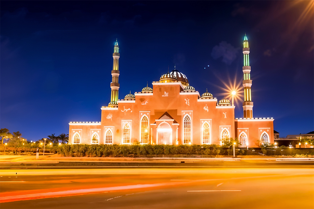 Beautiful mosque in golden lights under night sky