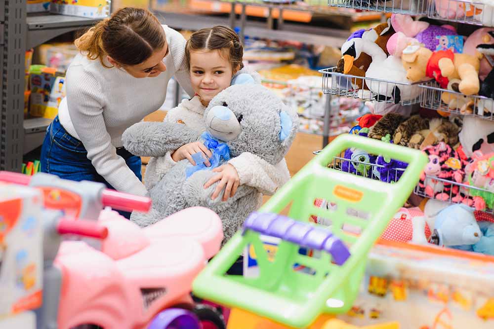 Parents buying stuffed toys to kids in toy store 