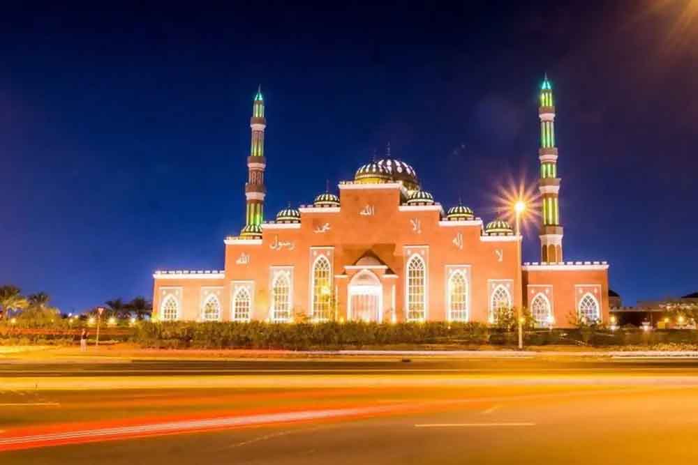 Beautiful mosque in golden lights under night sky