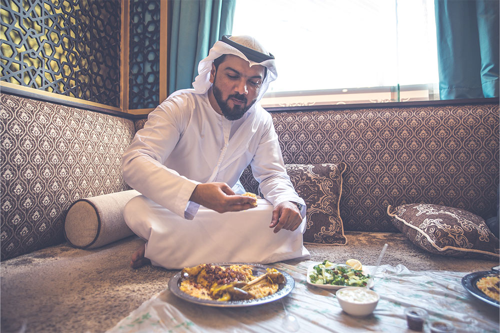 An Arabic man having traditional Arabic cuisine