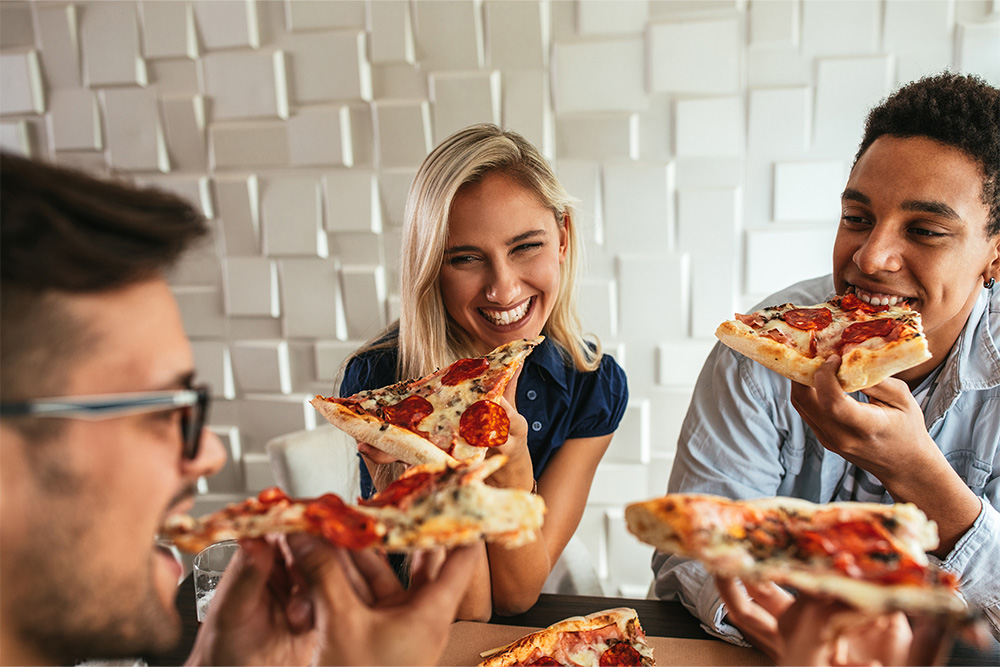 Group of friends eating pizza in a Italian restaurant