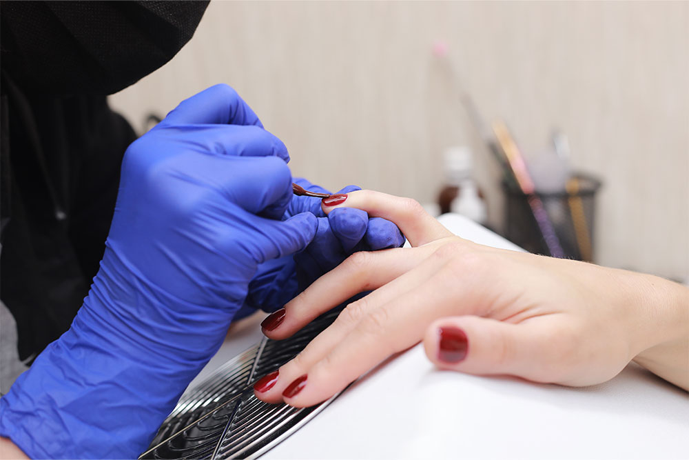 A girl taking the nail paint services in a nall salon 