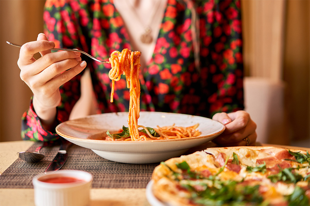 woman eating pasta in a restaurant in abu dhabi