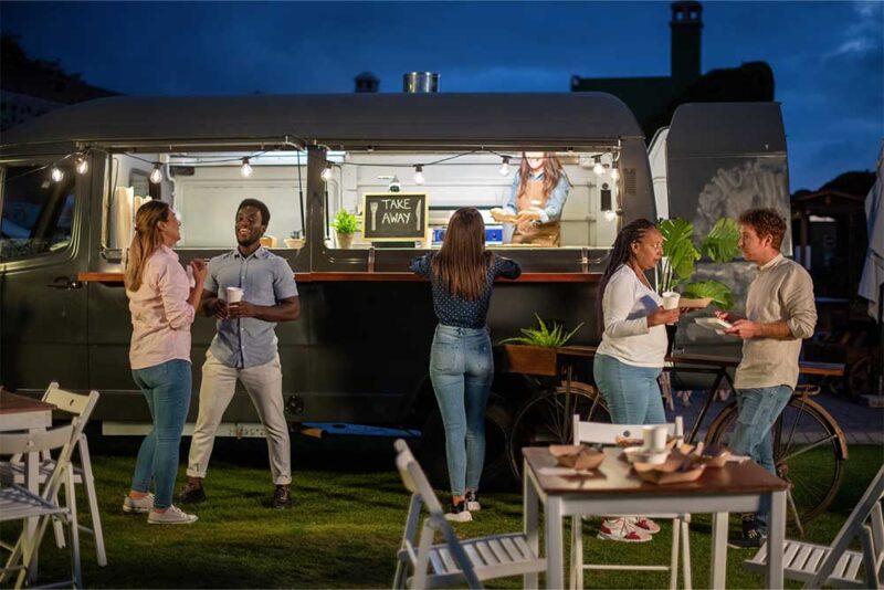 a group of friends eating at a food truck in abu dhabi