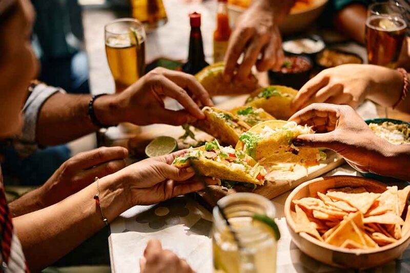 Closeup of people eating Mexican food