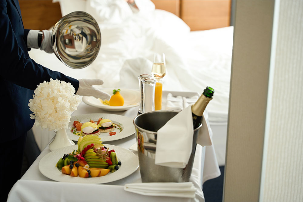 Server serving breakfast in the room